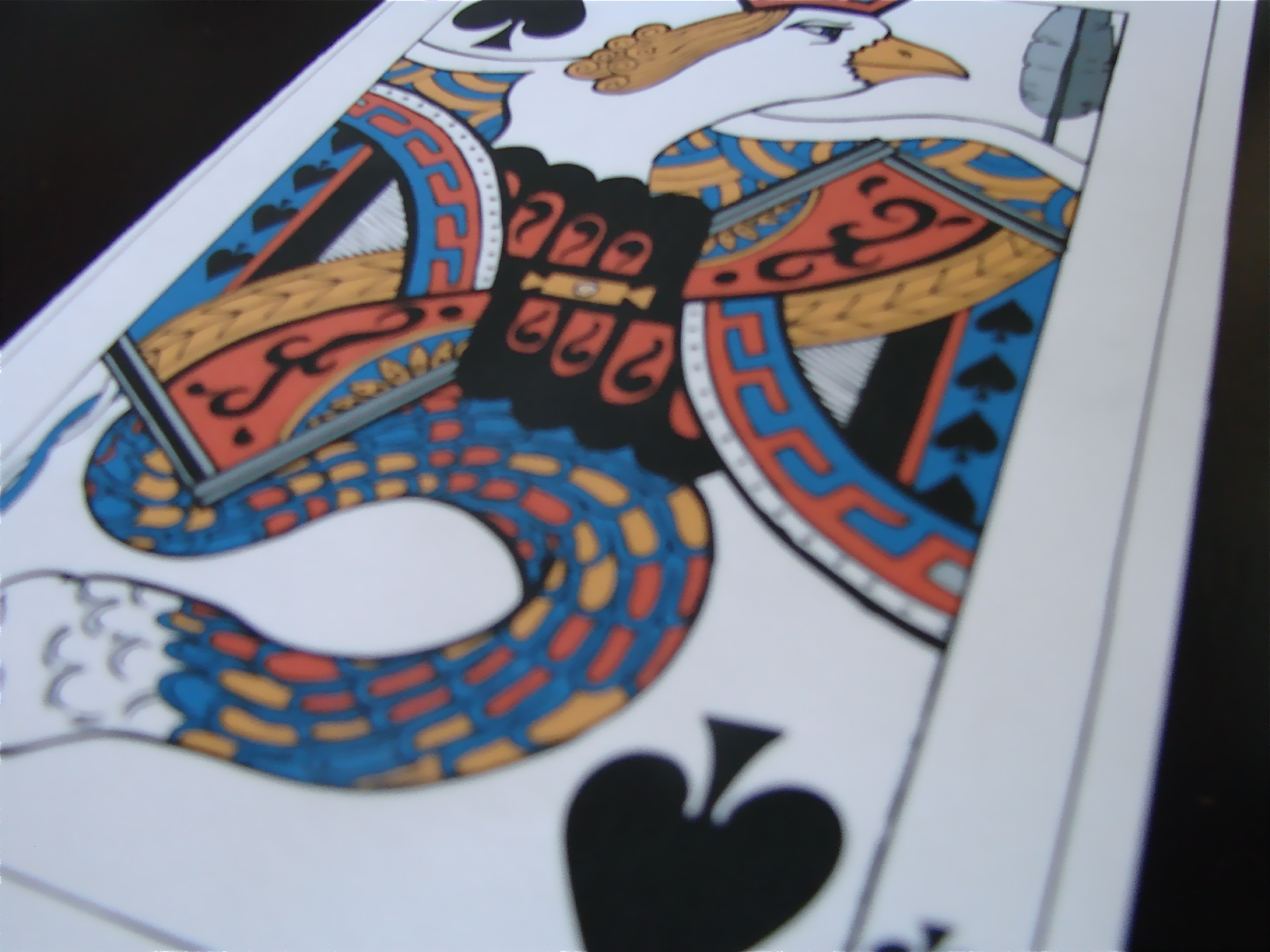 Close-up of a stylized Ace of Spades playing card with an eagle-and-serpent design, from Dove & Snake, issue 2.